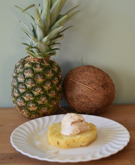 Boozy rotisserie pineapple with coconut ice cream all ready to be eaten